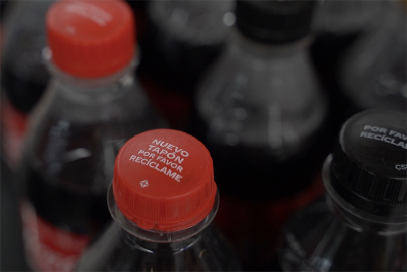 Nuevos tapones adheridos a las botellas de Coca-Cola