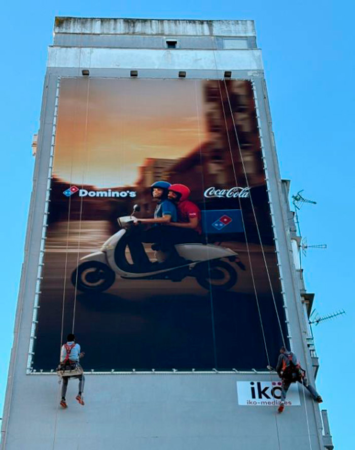 Dos repartidores anuncian la alianza entre Domino´s y Coca-Cola.